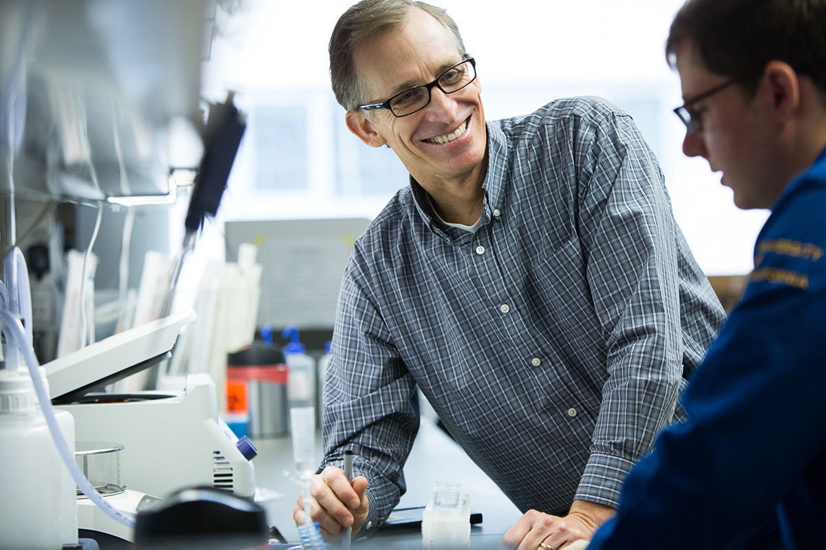 A man smiling while talking to another man